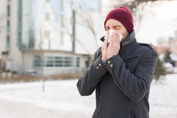 man_blowing_nose_outside